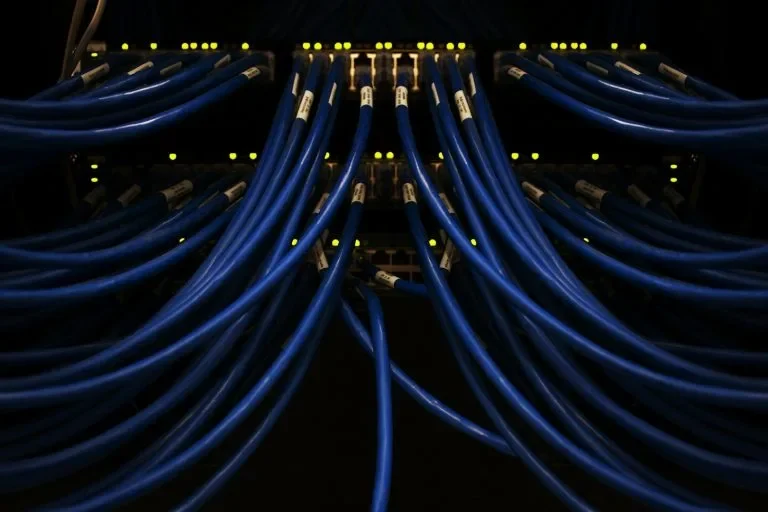 Blau beleuchtete Netzwerkkabel in einem Serverrack
